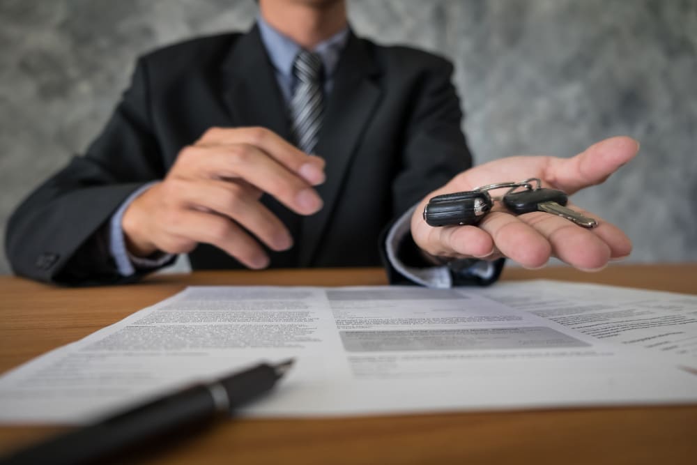 Lawyer handing car keys over contract