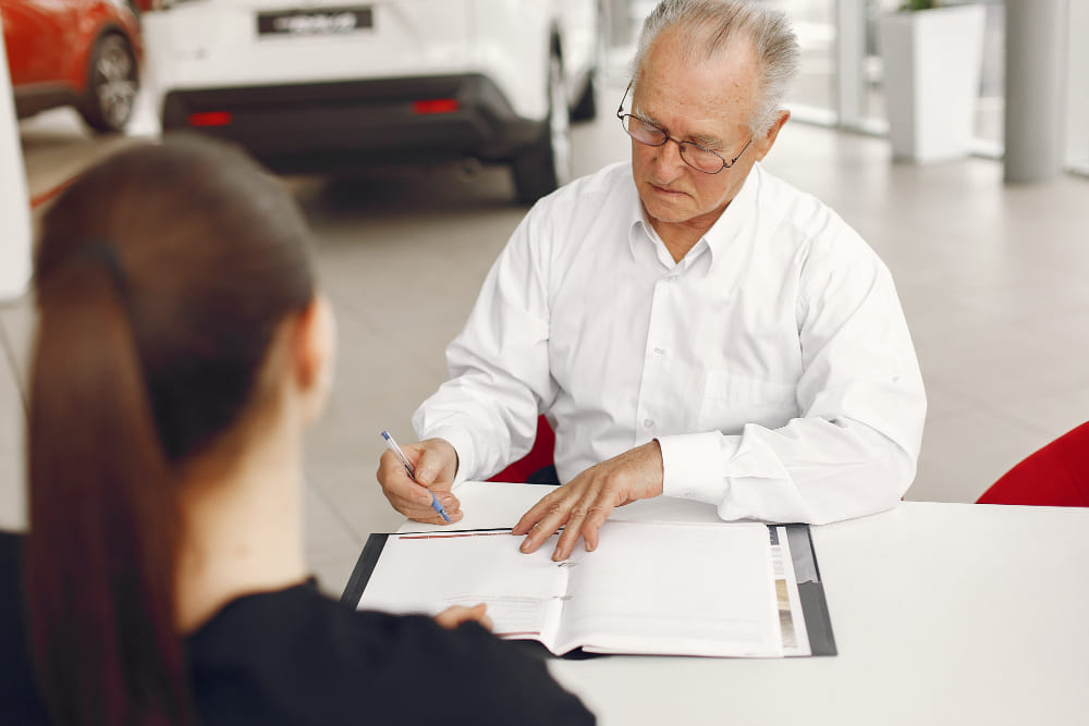Man in a white shirt reviewing and signing documents