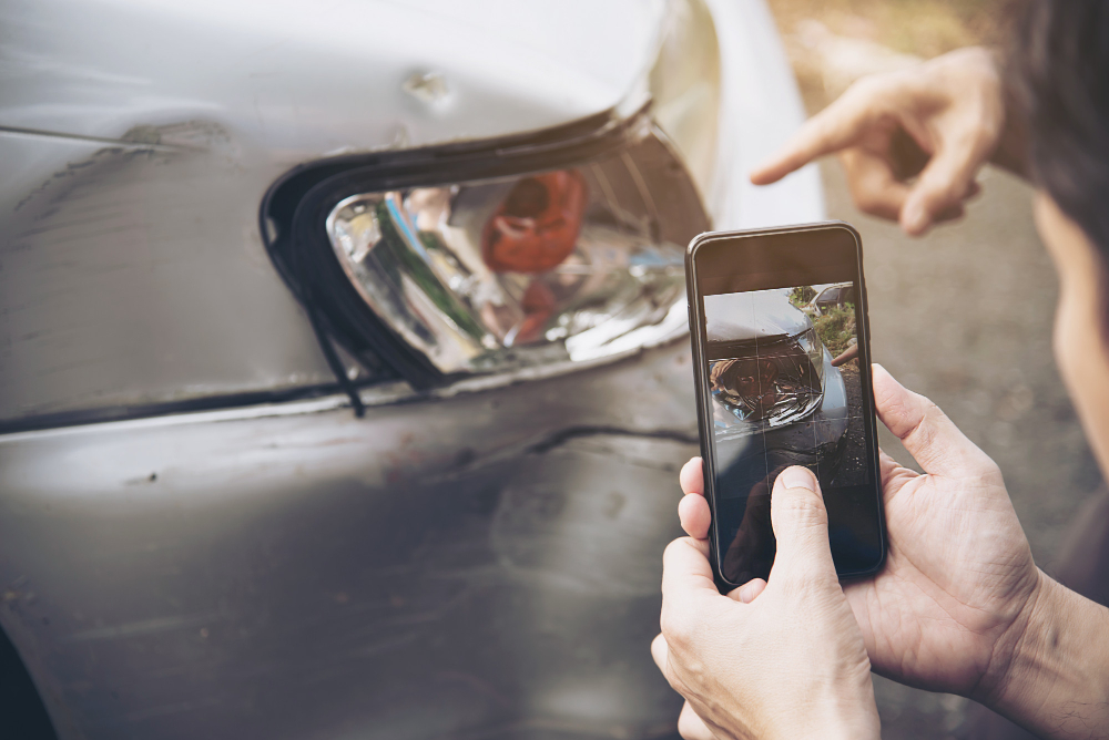 Person taking a photo of a car's damaged