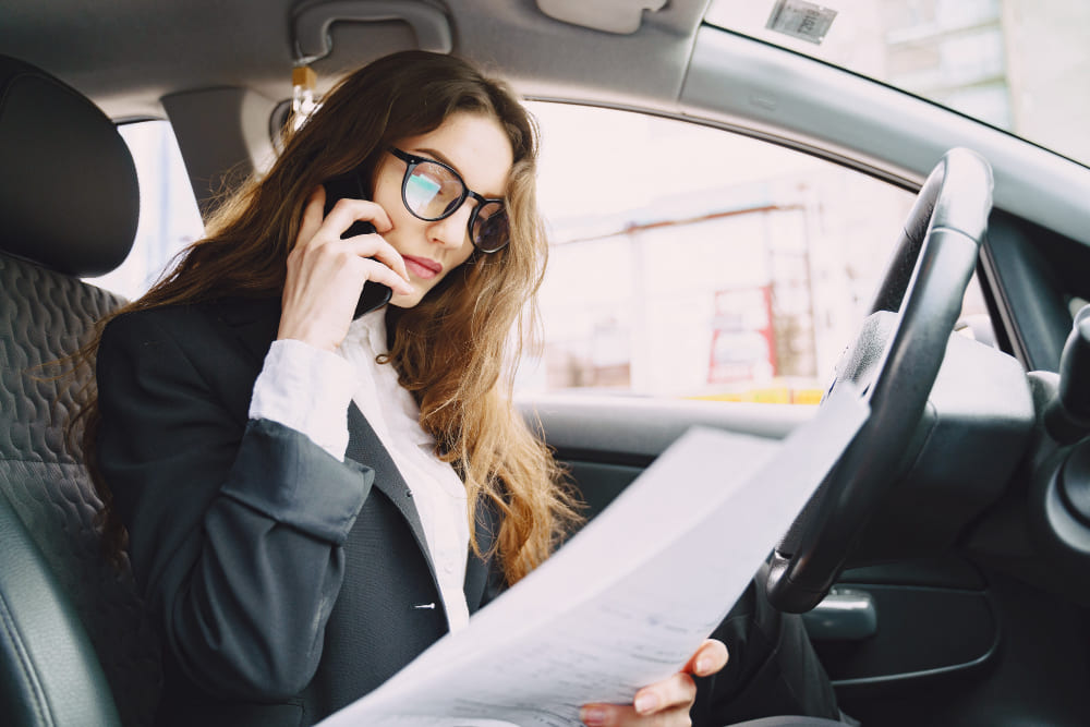 Woman sitting in a car, talking on the phone
