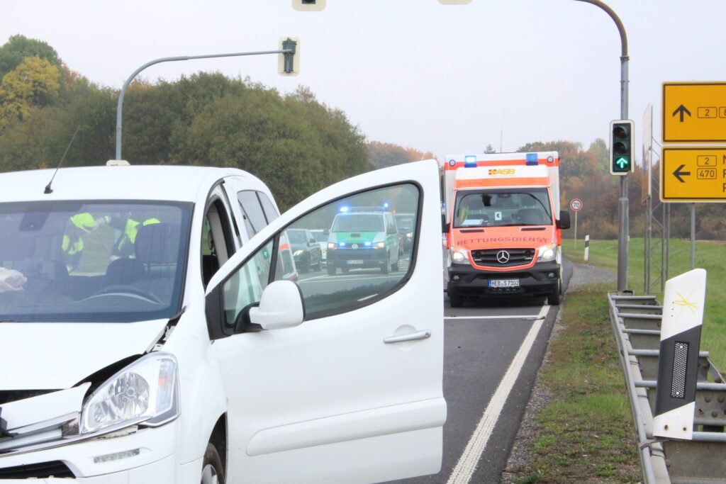 A damaged white van with an open door on a highway