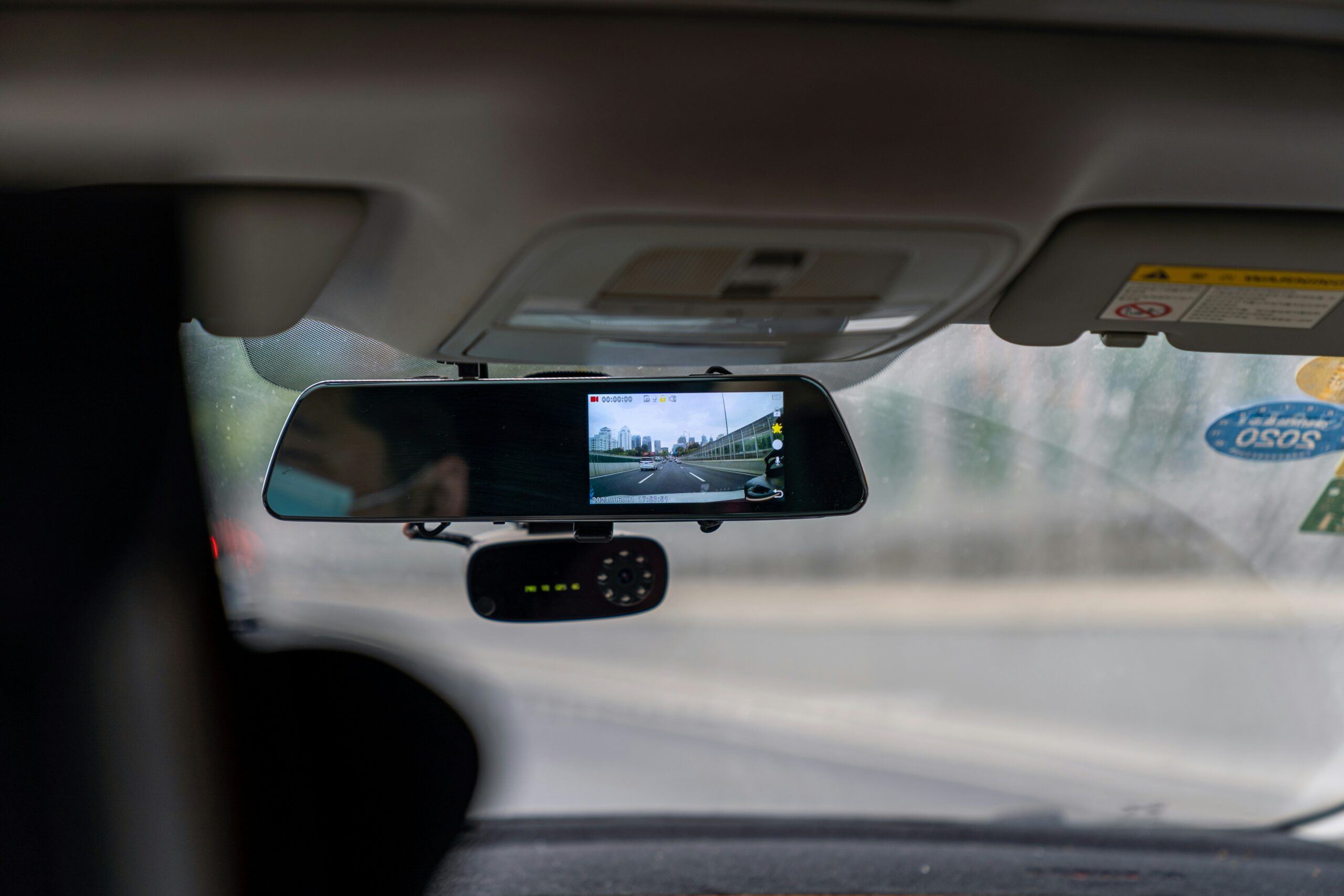 Rearview-mirror dashcam recording the road ahead from inside a car