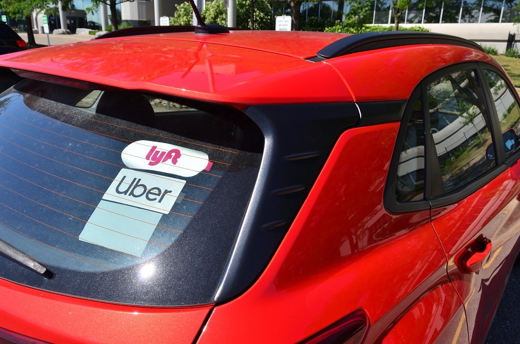 Car with Uber and Lyft rideshare stickers in the rear window