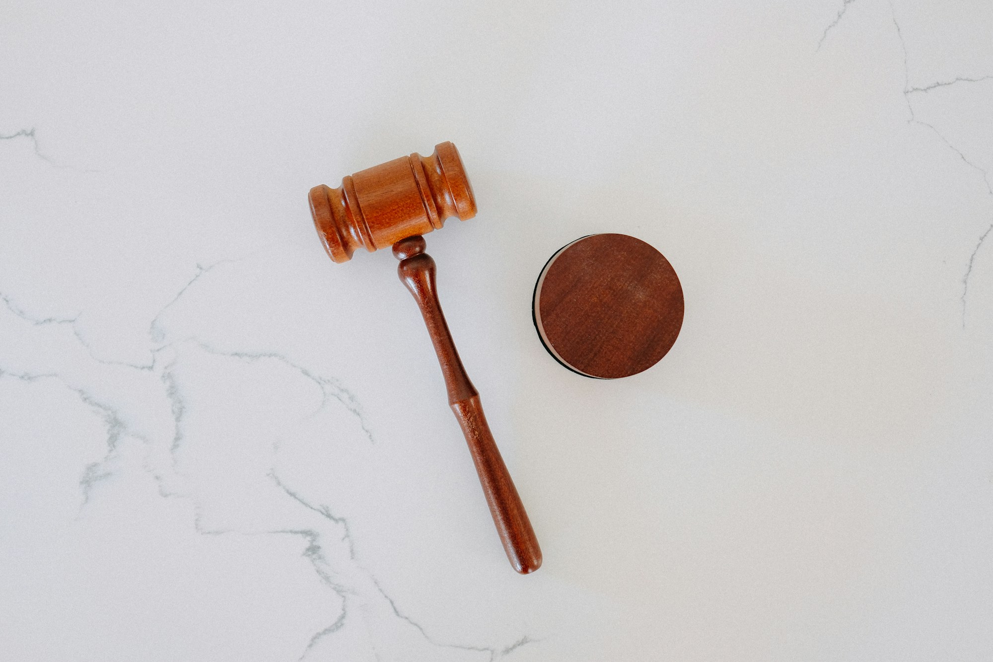 A wooden judge's gavel and sound block on a marble surface, representing the legal consequences of a habitual traffic offender designation